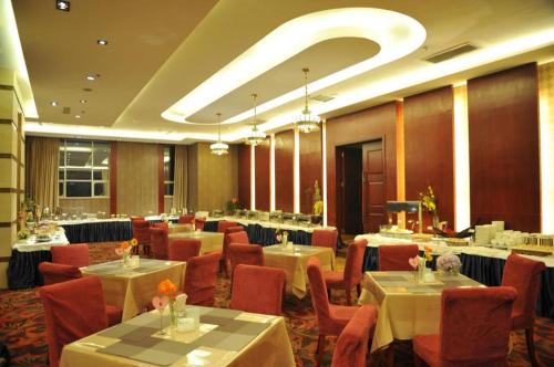 昆明Kunming Zhong Huang Hotel的一间在房间内配有桌椅的餐厅