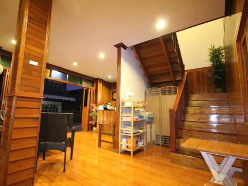 清刊Ban Glai Kong的客厅设有楼梯和桌椅