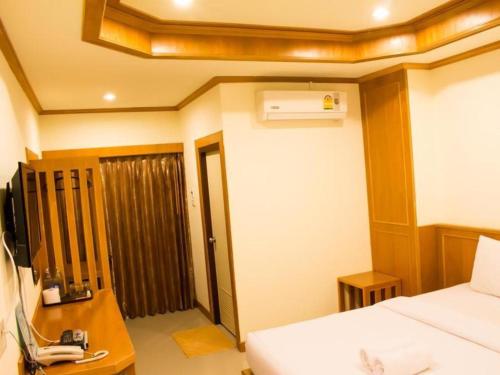 Ban Tha PhaeLoei Residence的客房设有一张床、一张书桌和一部电话