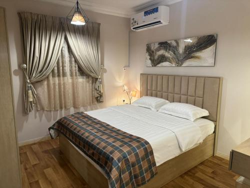 阿可贺巴شقق روز الفندقية دخول ذاتي的一间卧室设有一张大床和一个窗户。