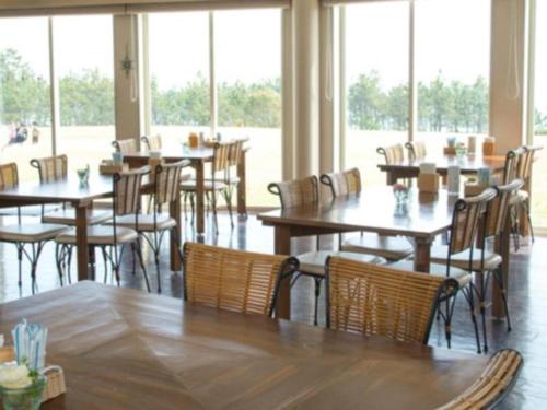 IrinoNest West Garden Tosa Hotel的餐厅设有木桌、椅子和窗户。