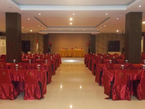 MaulafaJohn's Hotel的宴会厅配有红色椅子和桌子