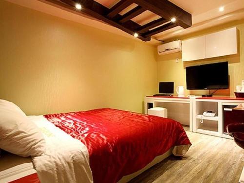 牙山市Asan ING Hotel的一间卧室配有一张带红色毯子的床