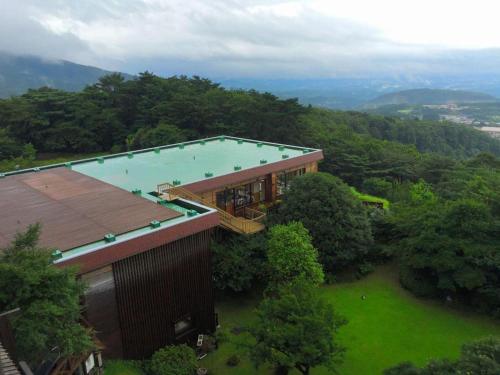 雾岛市Kirishima Onsen Ryokojin Sanso的享有带游泳池的大楼的顶部景致