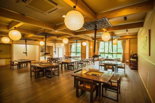 ItchūHotel Hikyounoyu的用餐室配有桌椅和灯光