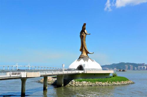 澳门L'Arc Hotel Macau的水面上的一座桥,上面有雕像