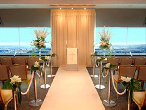 都城市Miyakonojo Royal Hotel的配有桌椅的房间和长走廊