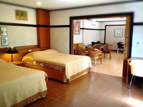 Ban Rong ChangNumsin Hotel的一间酒店客房,设有两张床和一间餐厅