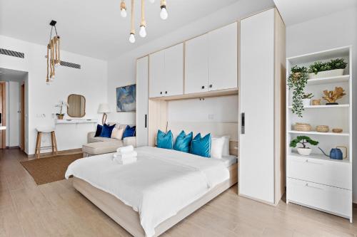 阿布扎比Mediterranean Getaway In Yas -Studio的卧室配有带蓝色枕头的大型白色床