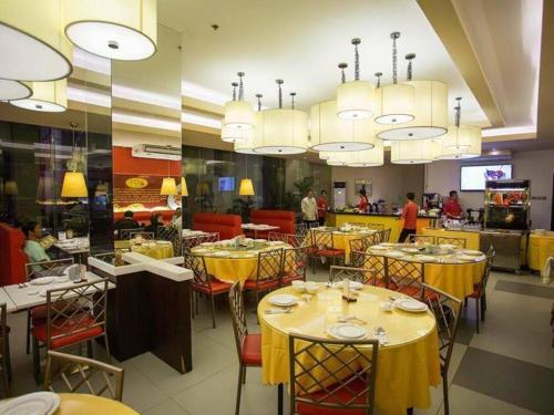 SantiagoIsabela Zen Hotel & Restaurant Corporation的用餐室配有黄色的桌椅