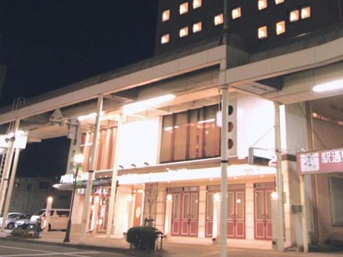 OshuMizusawa Grand Hotel的街上的一座建筑,晚上有红色的门