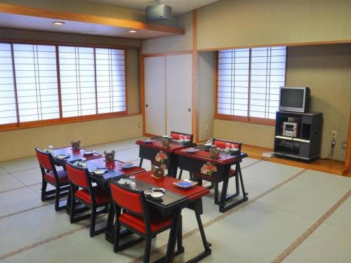 OniyanagimachiSenganishi Onsen Yumoto Azumakan的一间会议室,配有桌椅和电视