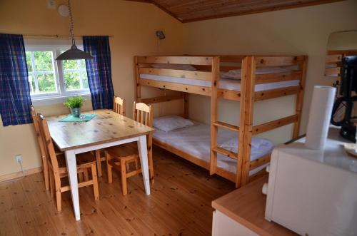 Ockelbo阿比戈壁中心假日公园的一间带双层床和桌子的房间以及一间用餐室