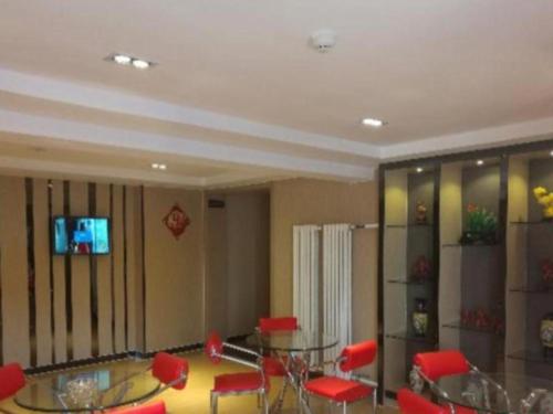 呼和浩特7 Days Premium Hohhot Hailiang Square的一间设有玻璃桌和红色椅子的房间