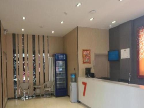 呼和浩特7 Days Premium Hohhot Hailiang Square的一间设有苏打水机和椅子的房间