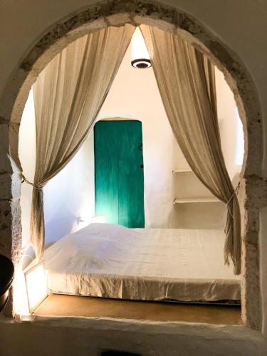 DjerbaDar Kenza的一间卧室配有一张带绿门的床