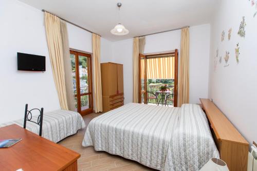 阿杰罗拉圣安娜住宿加早餐旅馆的一间卧室设有两张床、一张桌子和一个窗口。