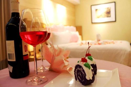 TanjungredepBUMI SEGAH HOTEL的一瓶葡萄酒、一块蛋糕和一杯葡萄酒
