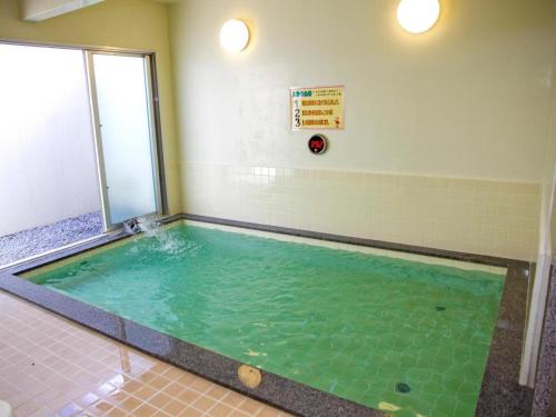 金武Nature Miraikan的室内的游泳池,有绿色的水