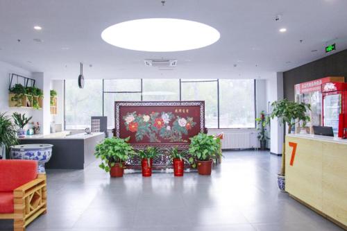 北京7 Days Premium Beijing Dabaotai Metro Station Luhua Road的墙上挂着盆栽植物和画作的房间