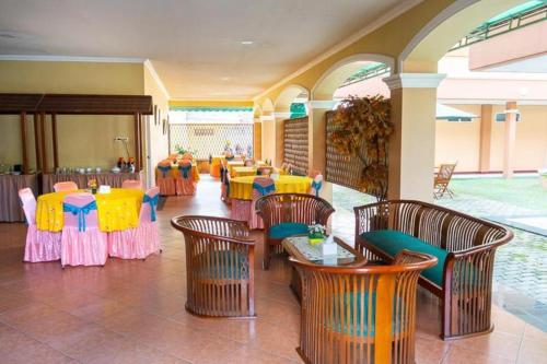 邦加槟港Hotel Griya Tirta的一间在房间内配有桌椅的餐厅