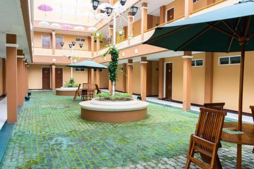 邦加槟港Hotel Griya Tirta的一座带椅子的庭院和一座位于大楼内的喷泉