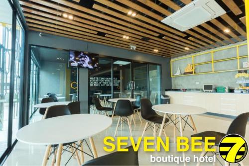 素辇府Seven bee boutique hotel的一间带桌椅和电视的用餐室