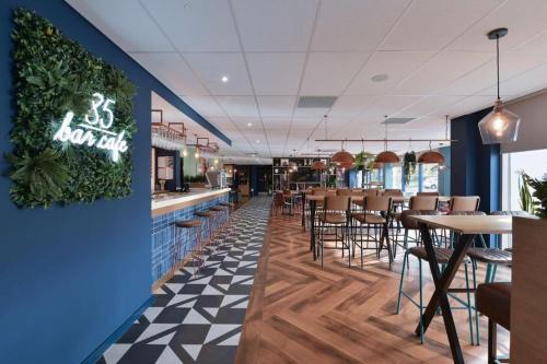 SheldonTravelodge Birmingham Airport的餐厅设有酒吧和桌椅