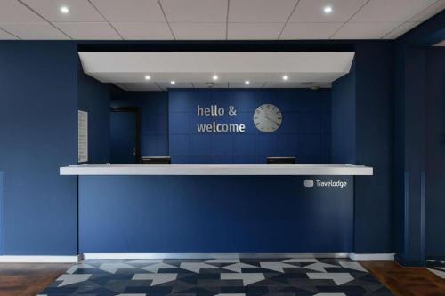 SheldonTravelodge Birmingham Airport的蓝墙,上面有计时器