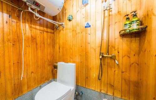 苏州The Courtyard Suzhou Inn Hemu Branch的木制浴室设有卫生间和淋浴。