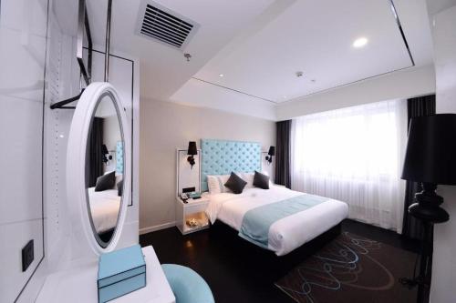 YufaXana Lite Hotel Beijing Daxing International Airport的一间卧室配有一张床和一面大镜子