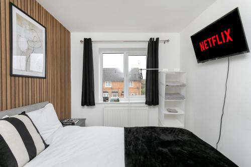 彼得伯勒4 Bed Contractor House-Parking-WiFi-Smart Tvs in Each Bedroom-Special Rates Available的一间卧室设有一张床和一个窗口