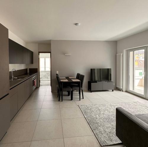 卢加诺Elegant Apartments in Lugano的厨房以及带桌子和电视的用餐室。