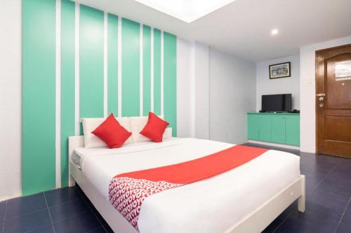 马尼拉OYO 128 d'Builders Rooms Phase 2的一间卧室配有一张红色和绿色条纹的床