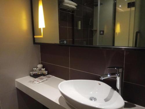 威宁IU Hotels·Bijie Weining Caohai Railway Station的浴室设有白色水槽和镜子