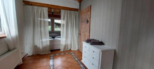 BahnsdorfAuszeit Wohnung Hof Narla的一间卧室配有一张床、一个梳妆台和一扇窗户。