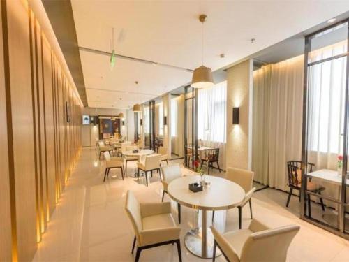 公明镇Jinjiang Inn Select Shenzhen Bitou Metro Station的餐厅设有桌椅和窗户。