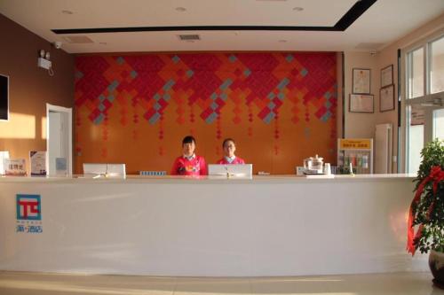 哈密PAI Hotel Hami Baoda Logistics Park Test Station的两个女人坐在商店的柜台上