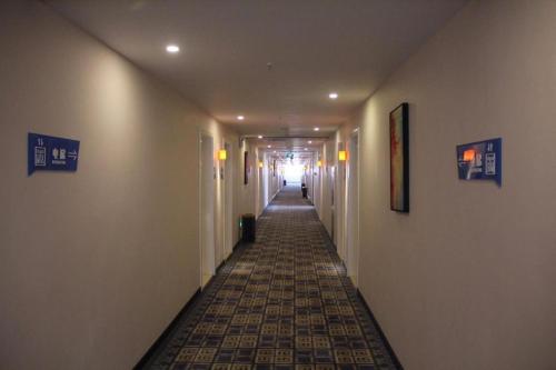 哈密PAI Hotel Hami Baoda Logistics Park Test Station的走廊设有长长的走廊,铺有瓷砖地板