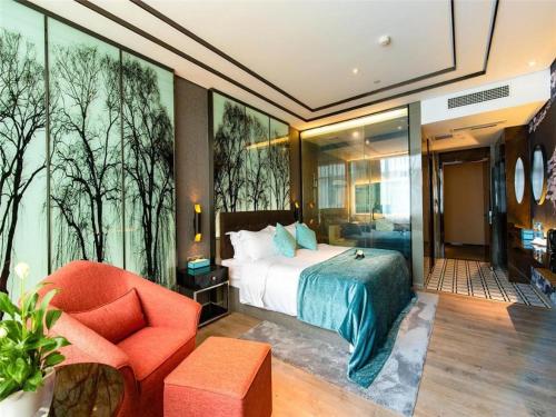 泸州Xana Hotelle·Hotel Luzhou Baizitu Square的配有一张床和一把椅子的酒店客房