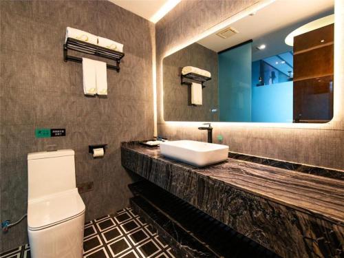 泸州Xana Hotelle·Hotel Luzhou Baizitu Square的一间带水槽、卫生间和镜子的浴室
