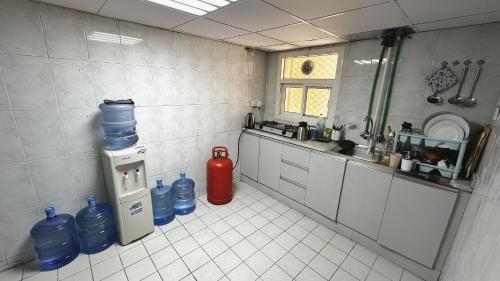 迪拜Dubai Zeus Hostel的厨房配有灭火器和水瓶