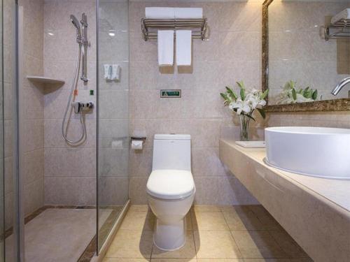 呼和浩特Vienna Hotel Inner Mongolia Hohhot Railway Station Gongzhufu Metro Station的浴室配有卫生间、盥洗盆和淋浴。
