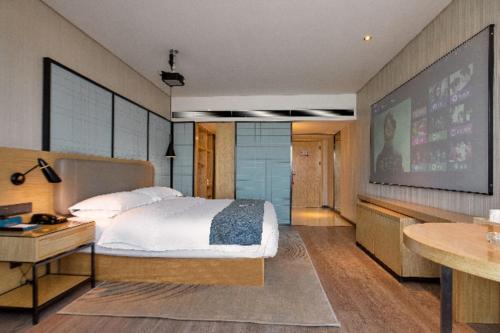 常德Echarm Hotel Changde Chaoyang D5 District的卧室配有床和大屏幕