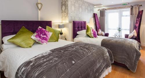 阿伯里斯特威斯Rooms by Maes y mor Town Centre的配有紫色和绿色枕头的客房内的两张床