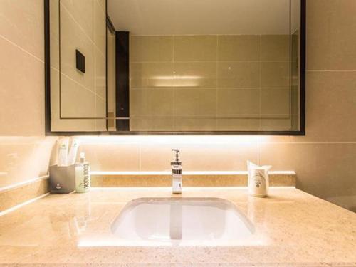 南宁City Comfort Inn Nanning Yudong Jinxiang Metro Station的浴室设有水槽、镜子和水槽