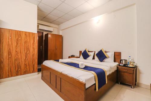 德拉敦Hotel PARAS TOWER的一间卧室配有一张带蓝色枕头的大床