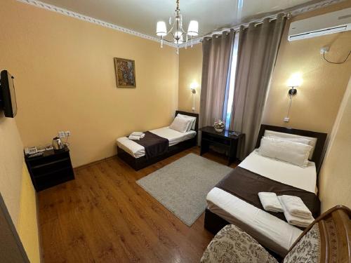 希瓦Hotel Euro Asia Khiva in Ichan Qala的一间小房间,配有两张床和一张沙发