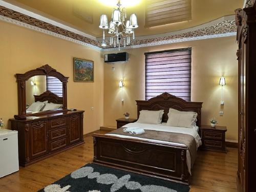 希瓦Hotel Euro Asia Khiva in Ichan Qala的一间卧室配有一张床、镜子和吊灯