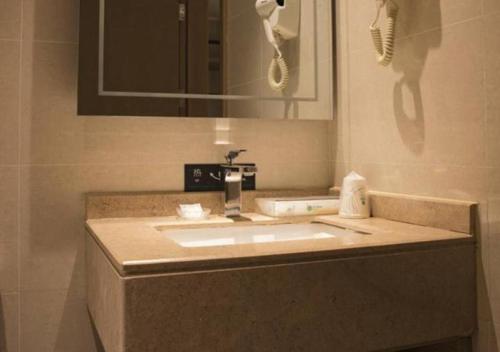 屯昌City Comfort Inn Hainan Tunchang Changsheng Road的浴室的柜台设有水槽和镜子
